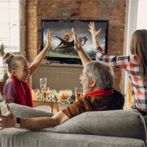 Family celebrating on the couch while football is on the television